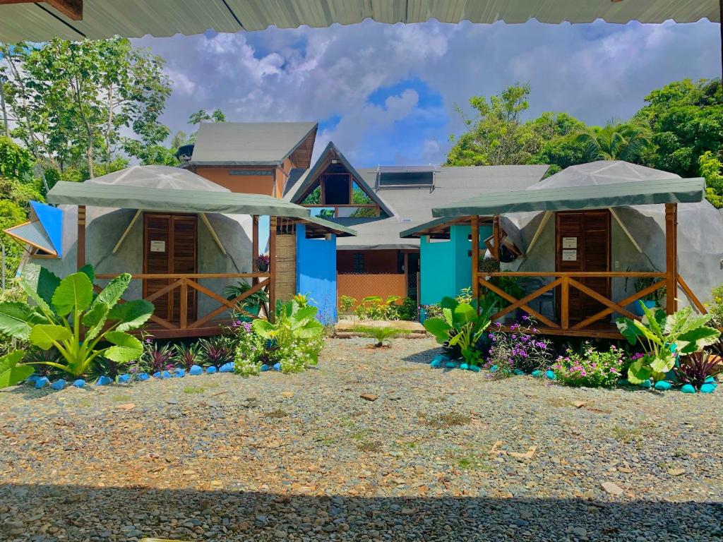 ein Haus mit zwei Sonnenschirmen davor in der Unterkunft Mi casa es tu casa Glamping in Capurganá