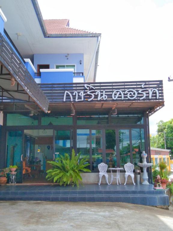 a building with two white chairs in front of it at Kasarin Court in Fang