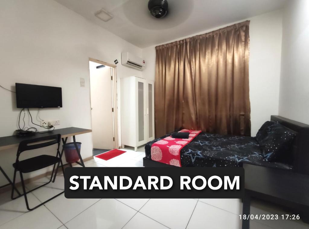 a room with a bed and a desk and a bed and a table at Shah Suites Vista Alam in Shah Alam