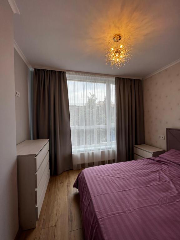 een slaapkamer met een paars bed en een raam bij Comfort for you in Ivano-Frankivsʼk