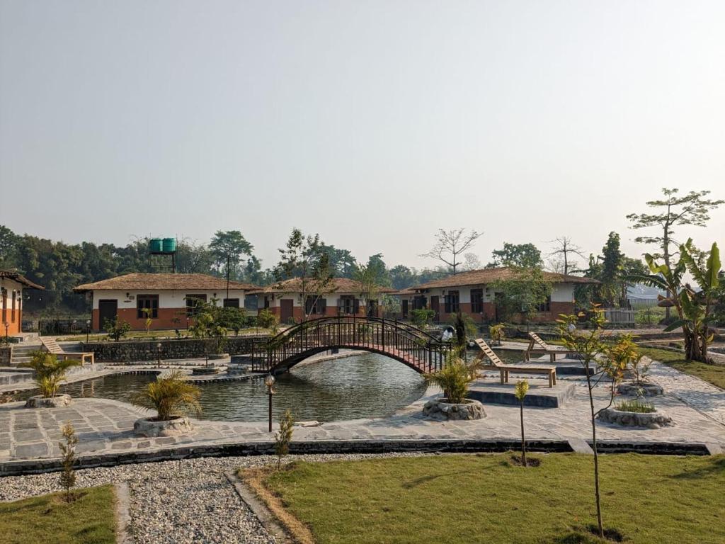 a bridge over a body of water in a park at Green Chwadi Nature Retreat in Kawasoti