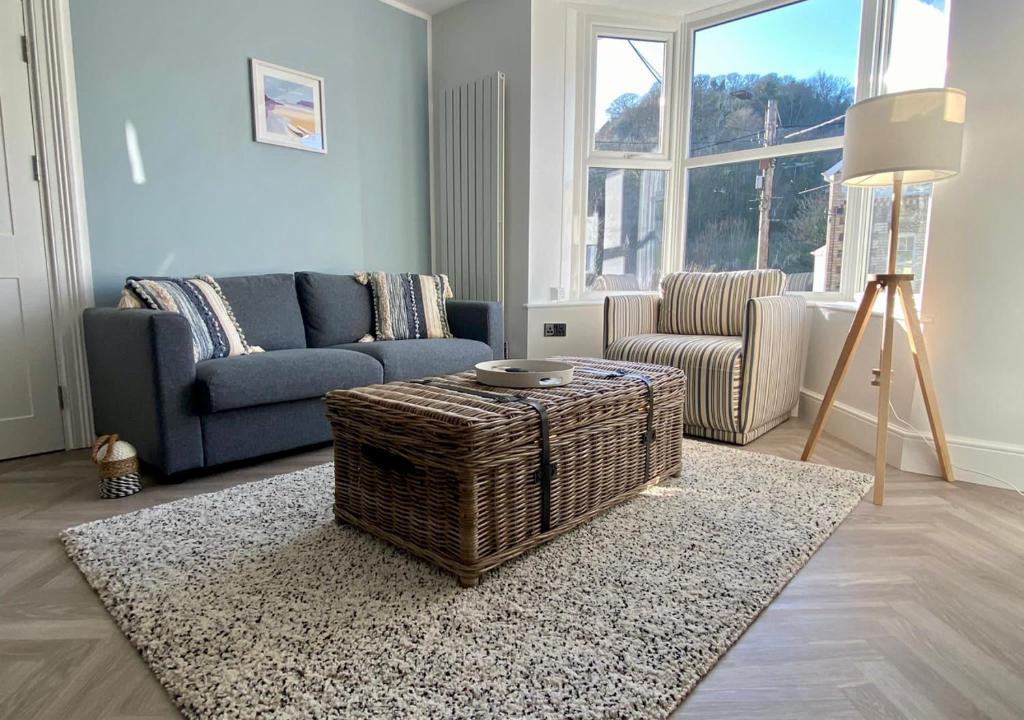 a living room with a couch and a table at ‘Sandy Bottom’ - Apartment by the sea in Combe Martin