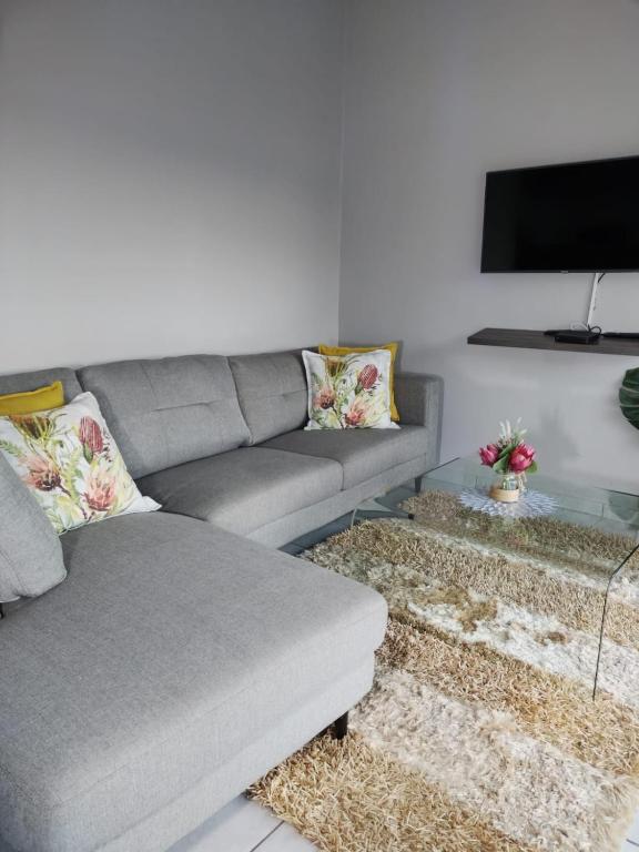 a living room with a couch and a tv at 19 Mirabelle Place in Pietermaritzburg