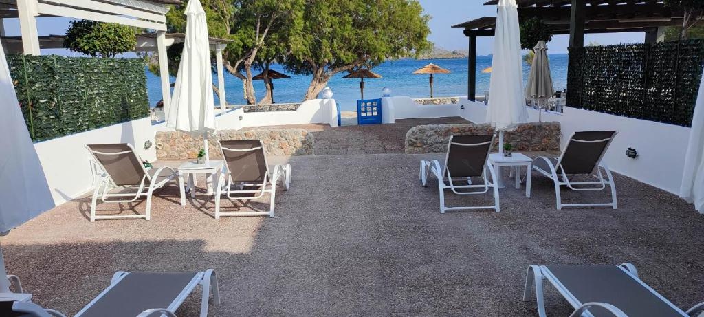 a group of chairs and tables with the ocean in the background at FILINA's luxury house in Maltezana