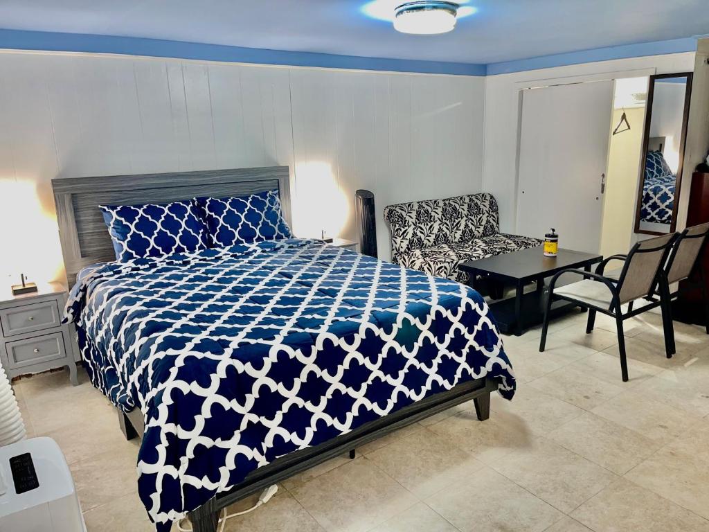 Un dormitorio con una cama azul y blanca y una silla en LGA Airport near, Studio walk in bsmt Apt in a Private House!, en East Elmhurst