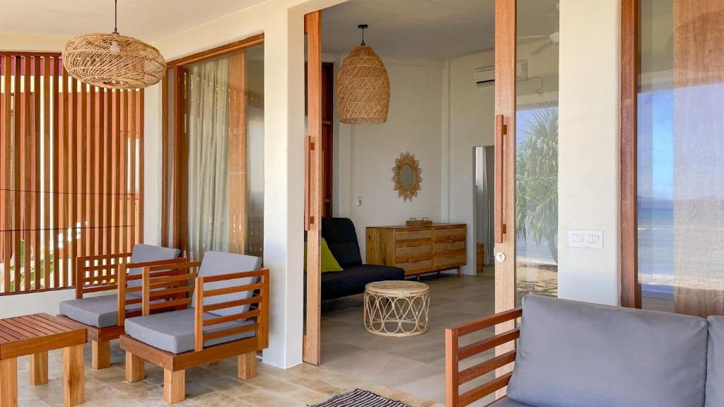 サバンにあるSunset Beach Resort Wehのリビングルーム(木製の椅子、テーブル付)