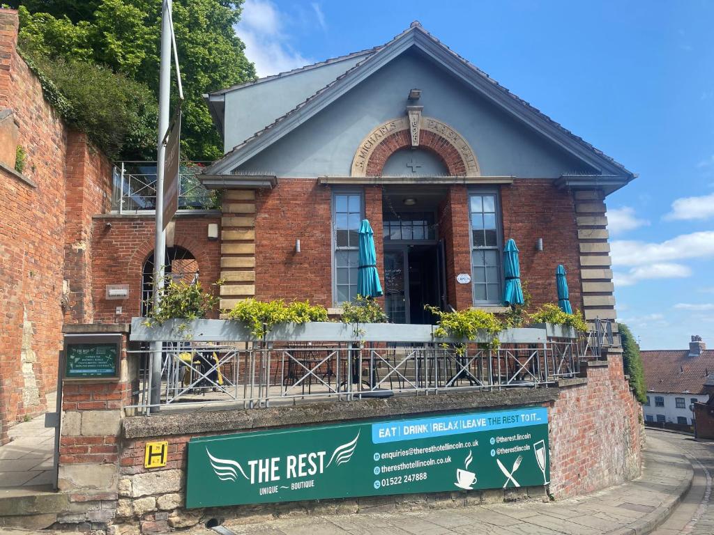 a red brick building with a sign in front of it at The Rest Hotel in Lincoln