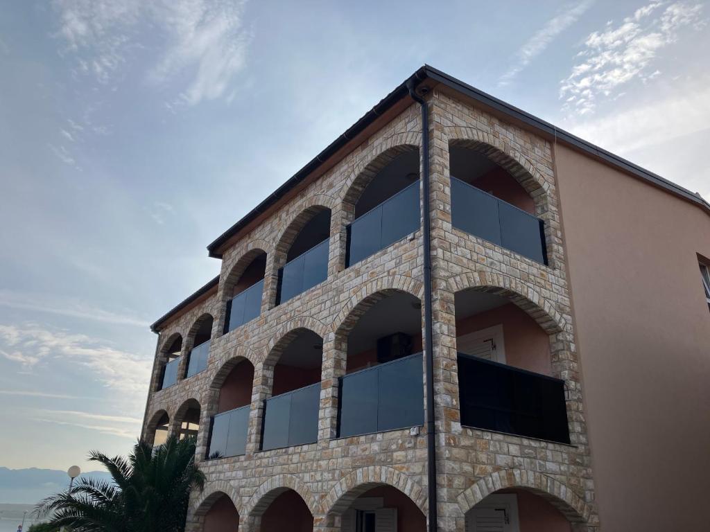 ein großes Backsteingebäude mit großen Fenstern in der Unterkunft Apartmani Ivanic in Vir