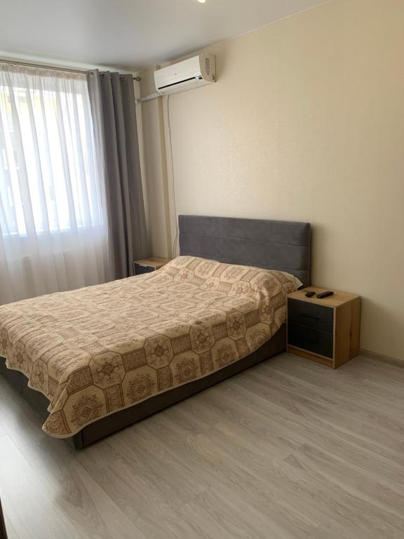 a bedroom with a bed and a night stand at Квартира ЖК 7 Небо Одесса Аквапарк Рынок-7 in Odesa