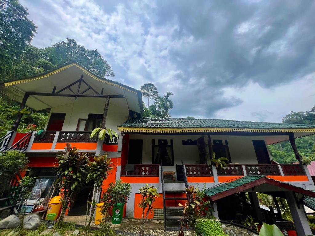 a house with an orange and white at Garden Grove Guest House & Coffee Bar in Bukit Lawang