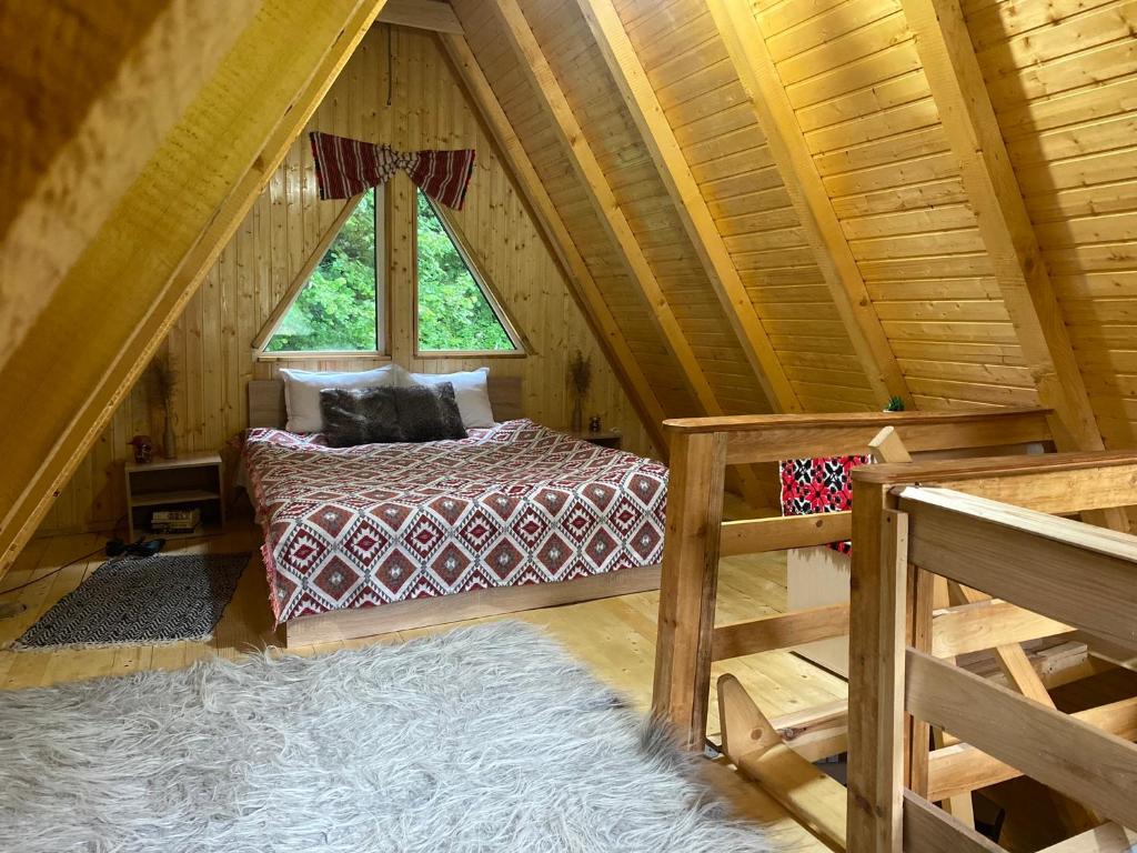um quarto com uma cama num chalé de madeira em Cabanutze Satic em Rucăr