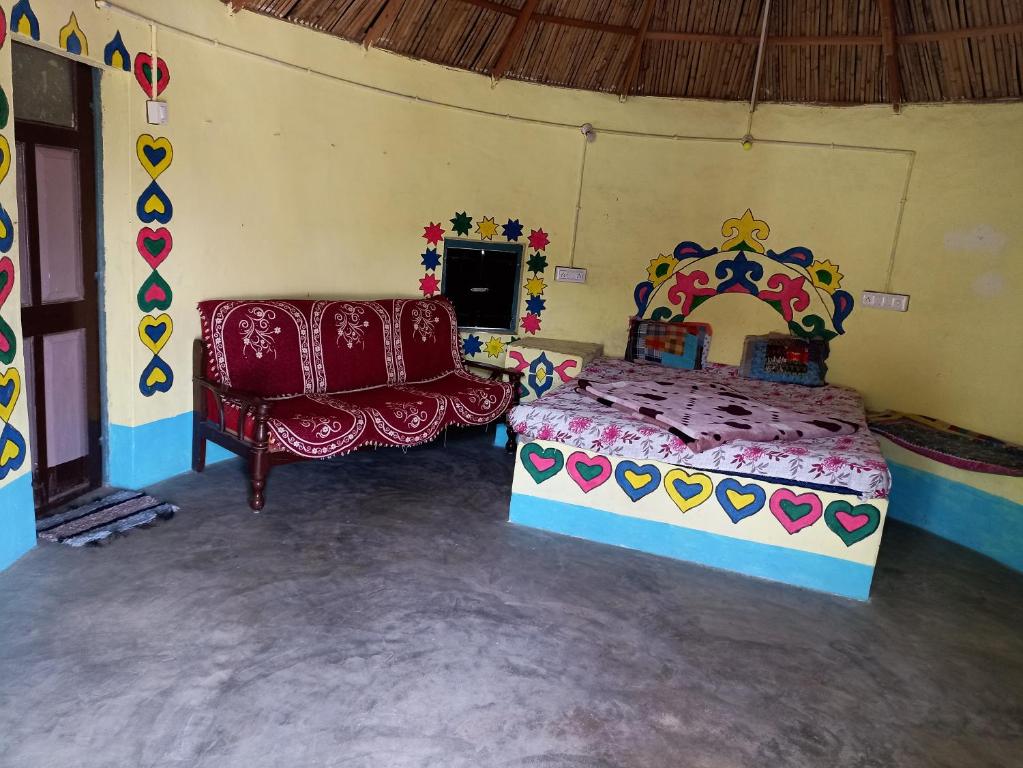 een slaapkamer met een bed en een bank in een kamer bij Rann of kutch home stay in Dhordo