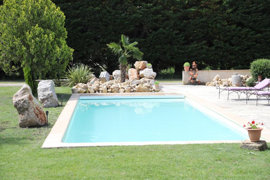 een groot blauw zwembad in een tuin bij La Bastide au coeur de la Provence in Pertuis