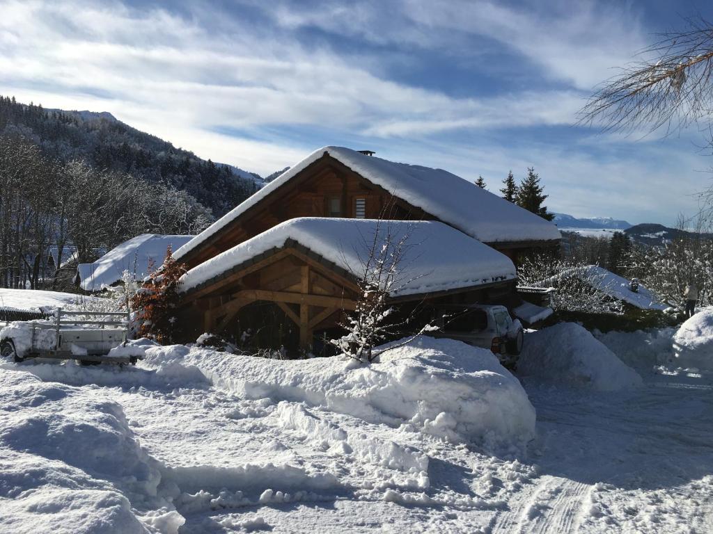 a cabin covered in snow with a pile of snow at Le chalet de Doucy Bardet in Habère-Poche