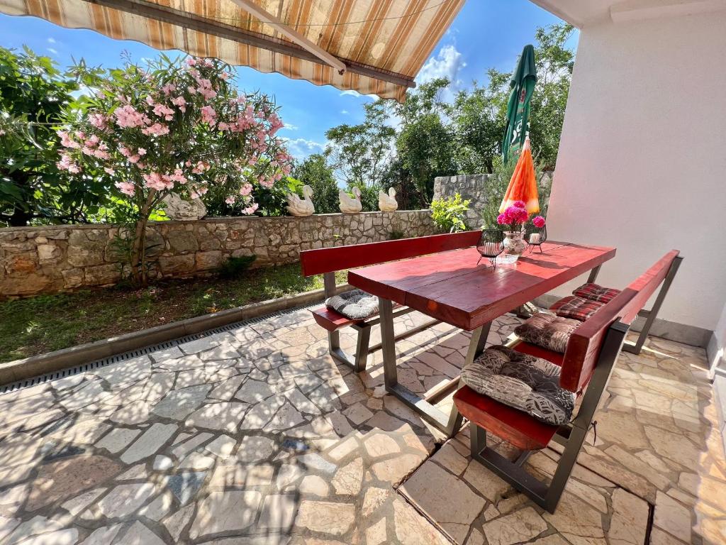a wooden table and chairs on a patio at Apartmani Ana in Dramalj