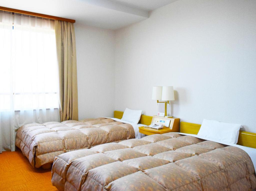 Postel nebo postele na pokoji v ubytování Hotel Gyokusen