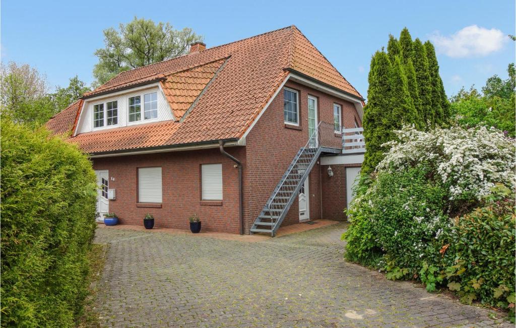 a brick house with a staircase in a driveway at Nice Apartment In Otterndorf With Kitchen in Otterndorf