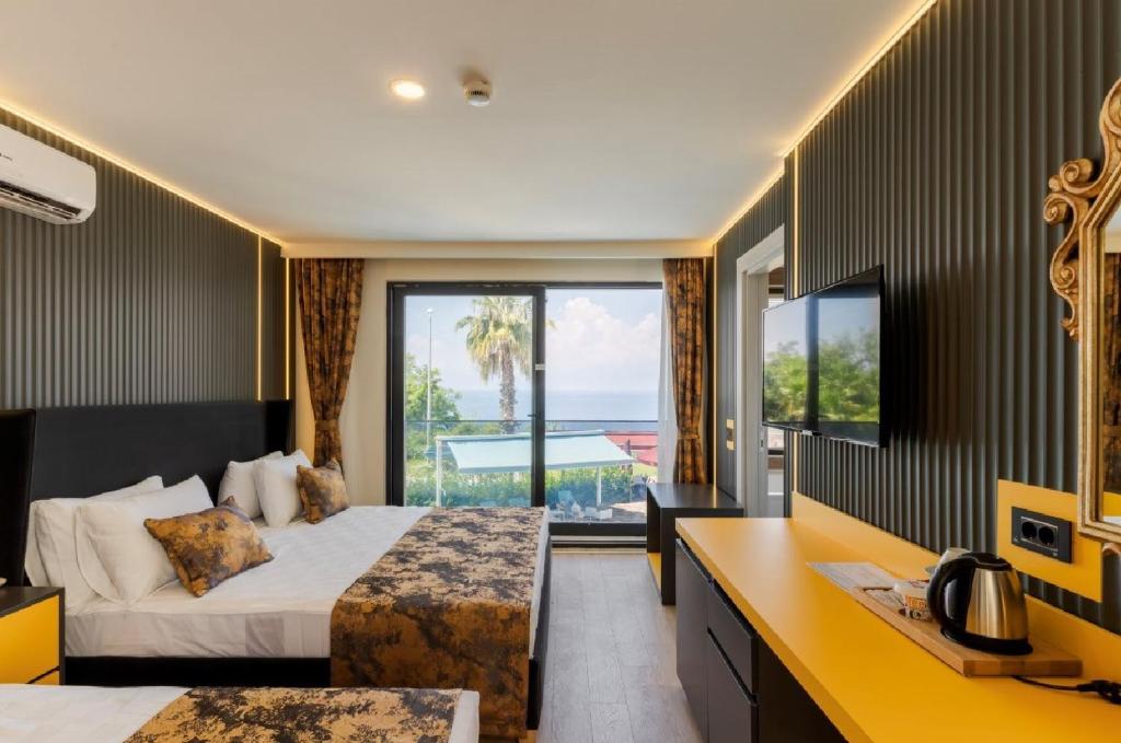 アンタルヤにあるTema 242 Hotelのベッドがあり、海が見えるホテルの部屋