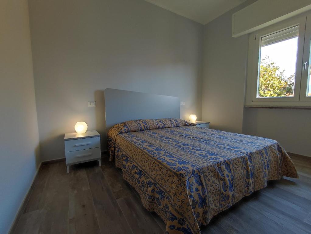 a bedroom with a bed and two lamps on a night stand at Casa Violina in Lido di Camaiore