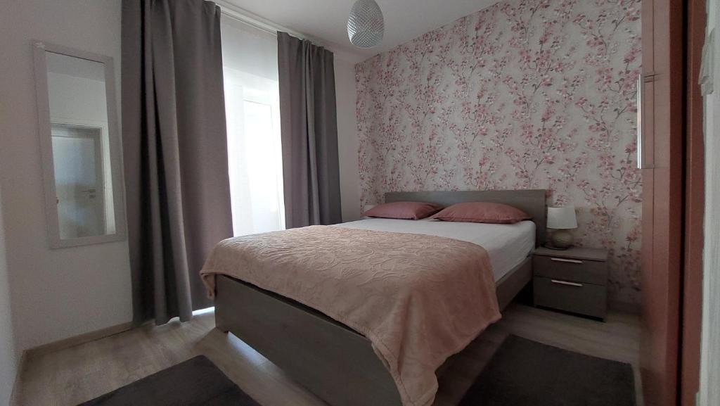 a bedroom with a bed with pink floral wallpaper at La Palma in Pakoštane