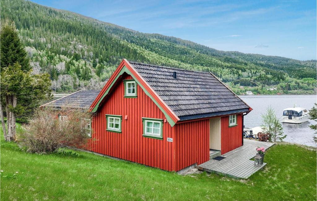 a red house on the side of a lake at Stunning Home In Mosvik With House Sea View in Mosvik