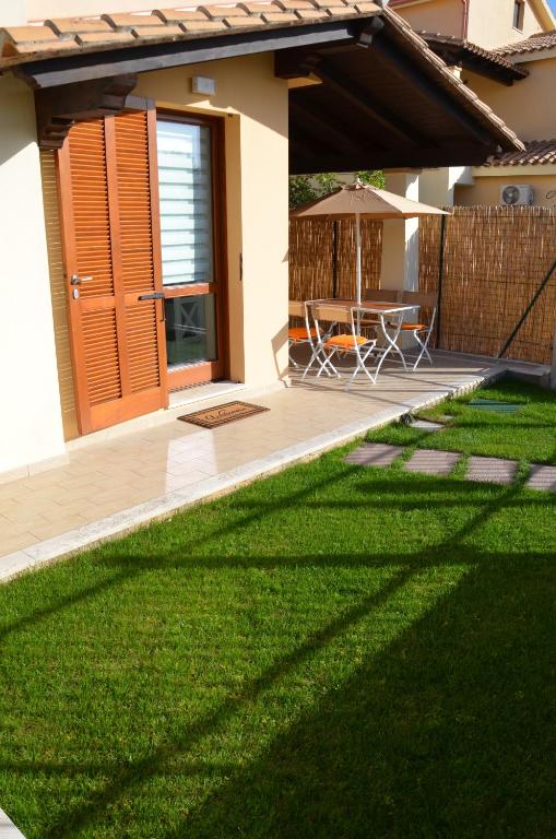 a patio with a table and an umbrella in a yard at Casa Vittorina in Pula