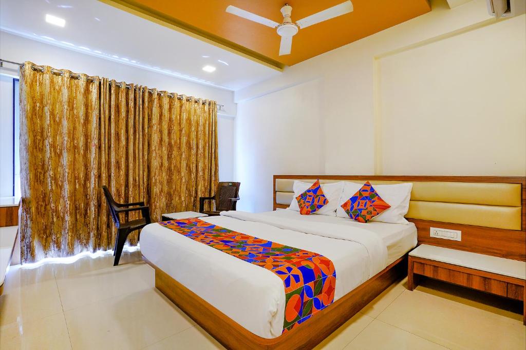 a bedroom with a large bed and a window at FabHotel Ramjis Residency in Nashik