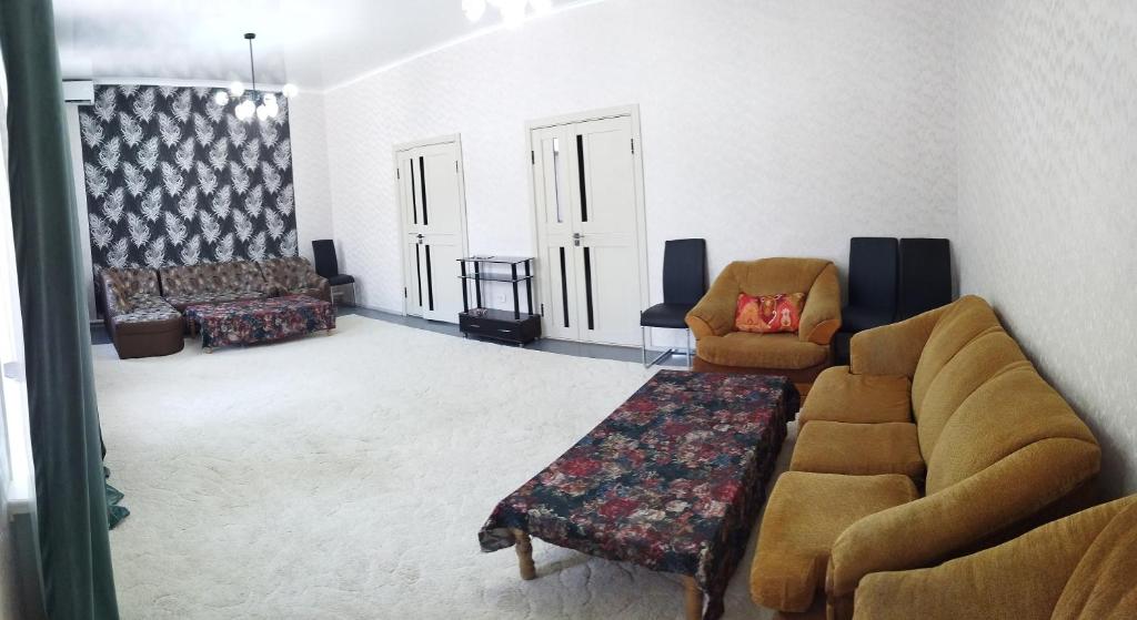 un soggiorno con un divano e due poltrone di Family house a Tashkent