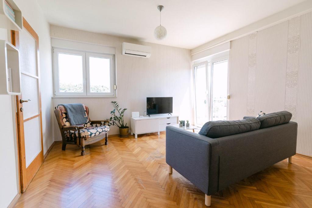a living room with a couch and a television at Cozy 2 bedroom apartment close to center in Split