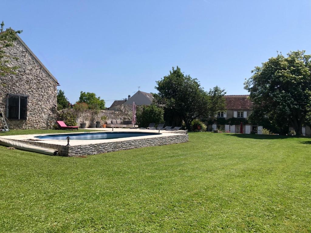 un patio con piscina y una casa en Large and chic house near DisneylandParis, Charles-de-Gaulle Airport and 45 mn from Paris, en Neufmontiers-lès-Meaux