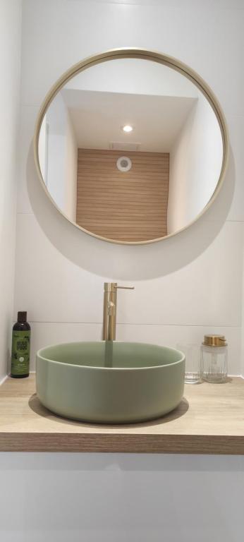 lavabo con espejo redondo encima en Studio appartement Port Soleil, en Saint-Mandrier-sur-Mer
