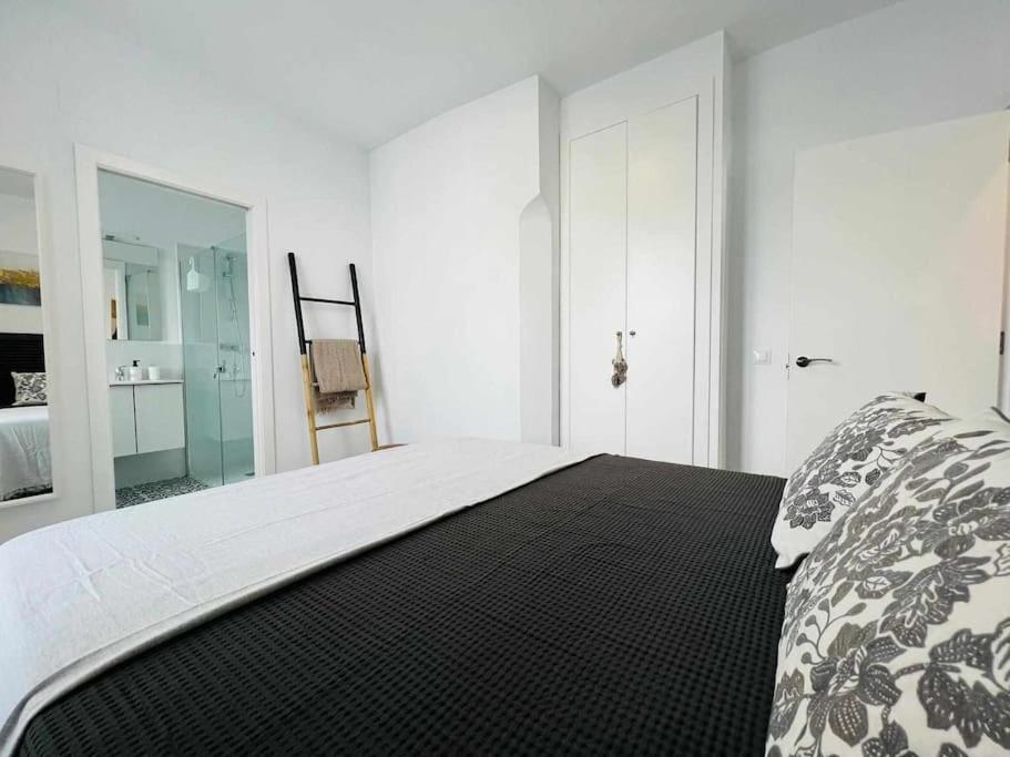 a white bedroom with a bed with a black and white blanket at Casa Las 4 Esquinas by Casas con Encanto in Medina Sidonia