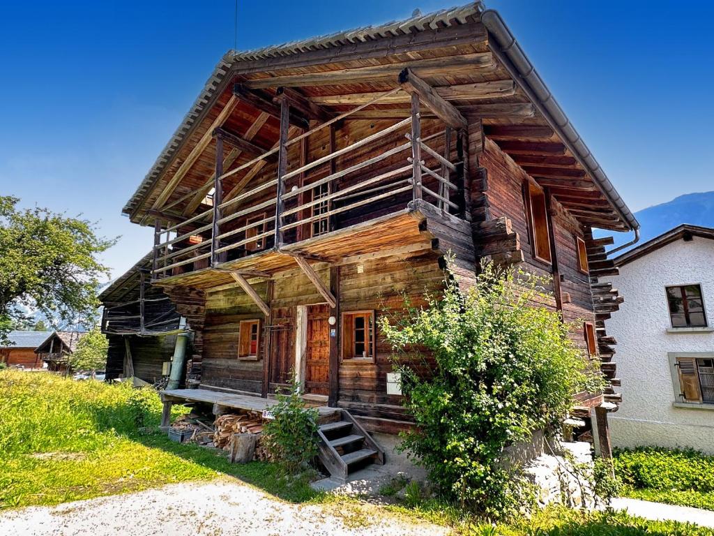 ein altes Blockhaus mit einer Treppe davor in der Unterkunft Chalet Karibu - 4 Vallees - A 20 mns de Verbier in Bruson