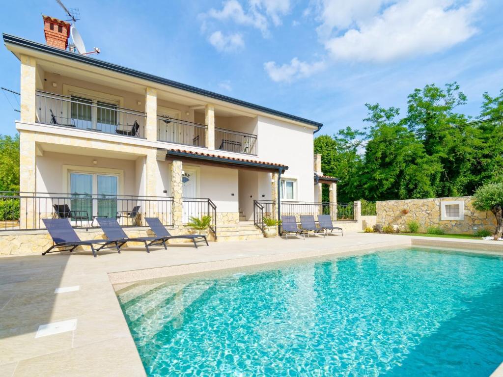 a villa with a swimming pool in front of a house at Villa Morgan in Umag