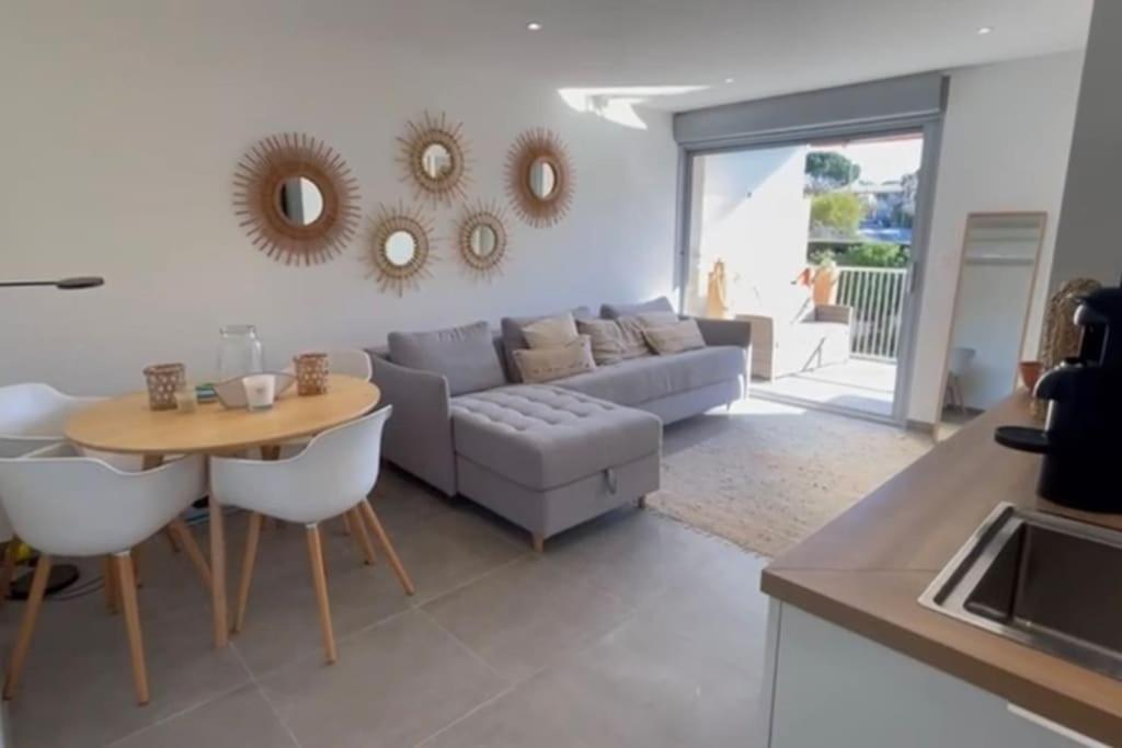 un salon avec un canapé et une table dans l'établissement appt St Tropez ,magnifique T2, piscine ,terrasse, emplacement ideal ,front de mer,, à Saint-Tropez