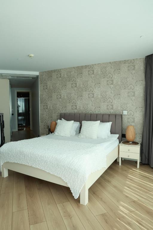 a bedroom with a white bed and a wooden floor at Prime Residence Istanbul-2-BDROOM in Istanbul
