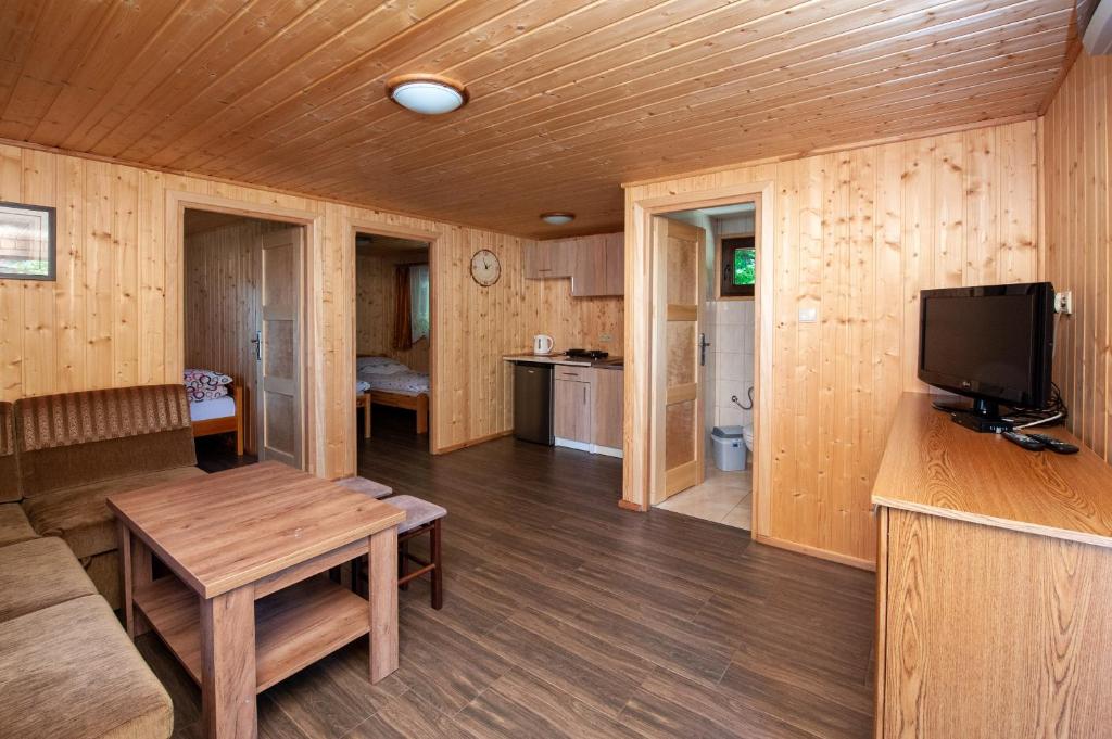 a wooden room with a table and a tv in it at Domki, pokoje u Małgosi in Sztutowo