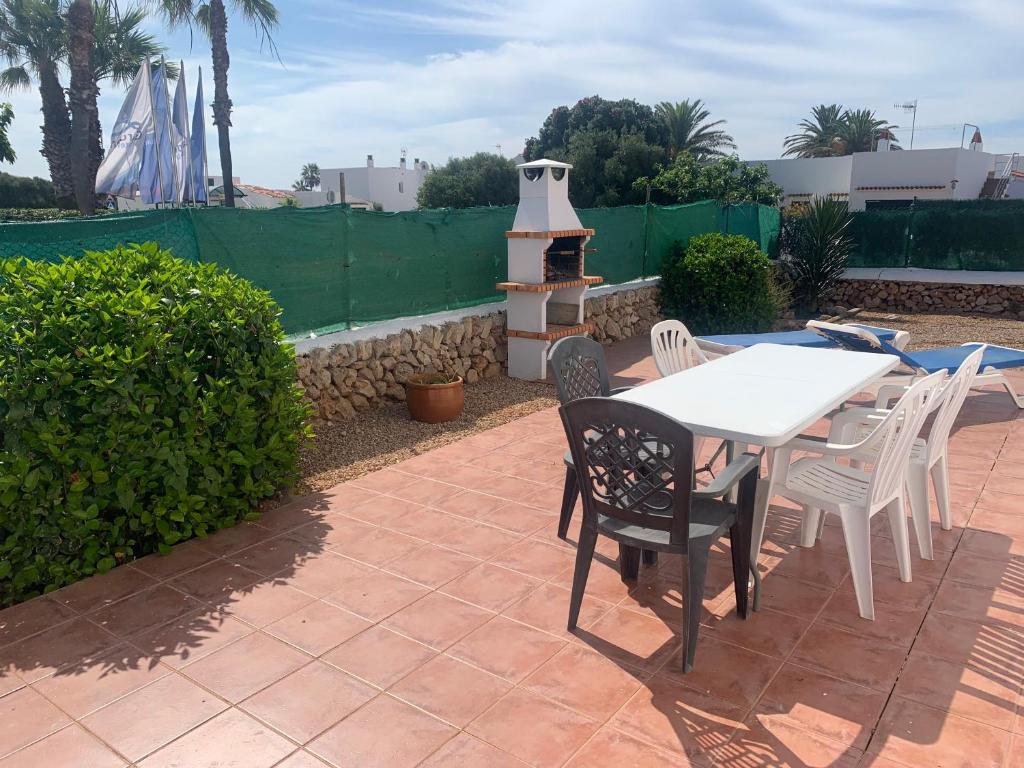 un patio con mesa, sillas y parrilla en Gran casa con Bonito Jardin, en Cala'n Bosch