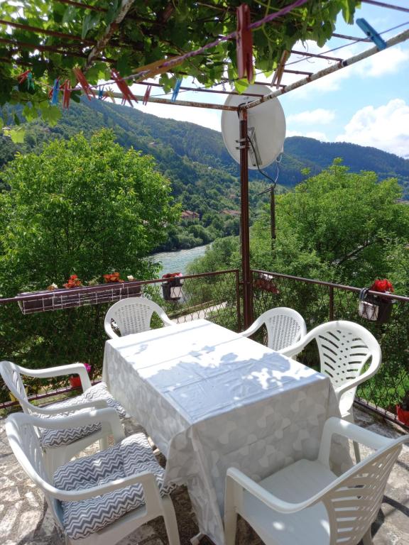 un tavolo bianco con sedie e vista sul fiume di MALA KUCA a Foča