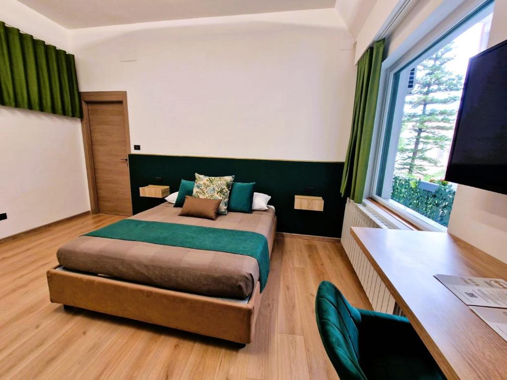 a bedroom with a bed and a desk and a window at B&B ONE in Catania