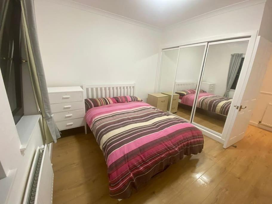 Schlafzimmer mit einem Bett, einer Kommode und einem Spiegel in der Unterkunft Steps Away from All the Action in Edinburgh