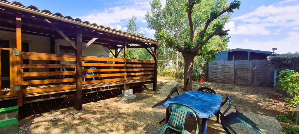 a table and chairs in a yard with a shed at Mobil-home 6 personnes sur terrain 600 m2 in Vias