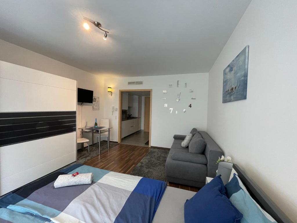 a bedroom with a bed and a couch in a room at Relax and Spa - DeLux Apartman in Velence