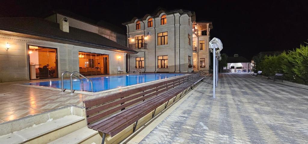 a house with a swimming pool in front of a building at Buzovna Villa in Baku