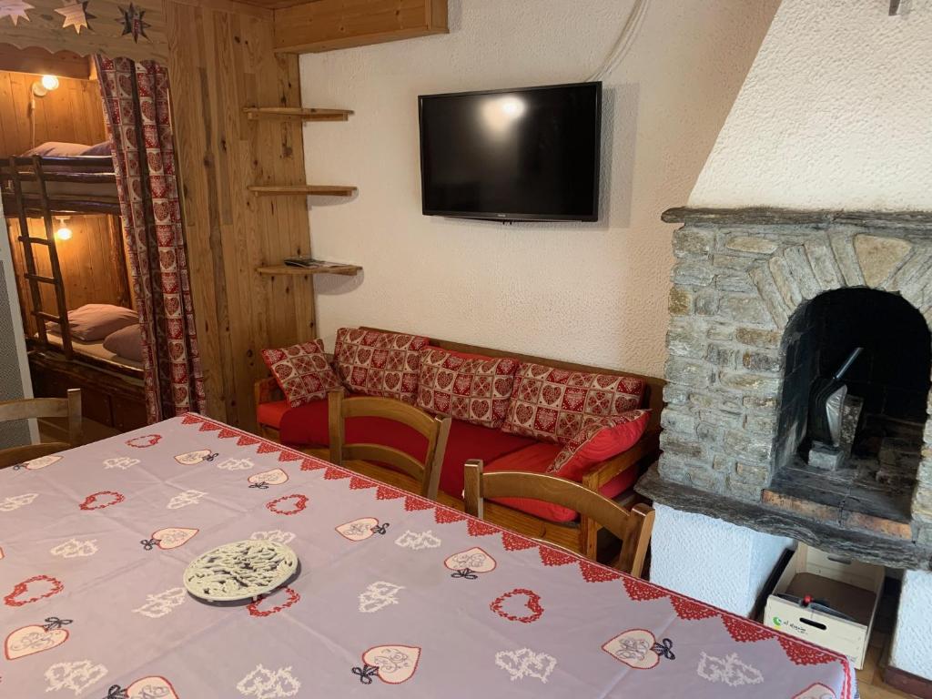 a dining room with a table and a fireplace at Le p&#39;tit coin montagne 3 in Bonneval-sur-Arc