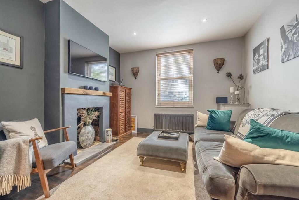 un soggiorno con divano e camino di Stylish 2-Bed House With Office And Private Garden a Windsor