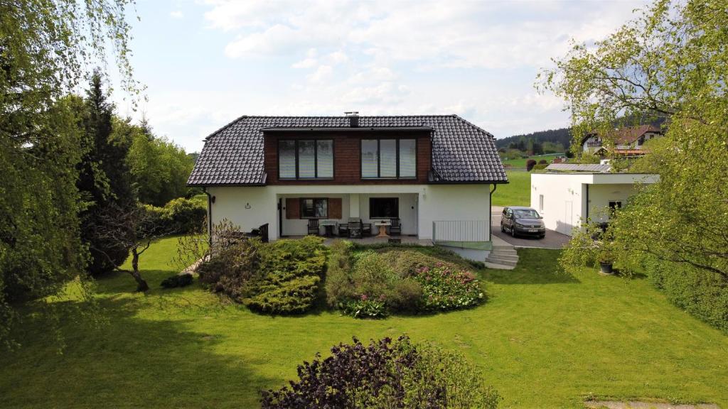 Casa blanca con techo marrón y patio en Haus Stadlau, en Klaffer am Hochficht