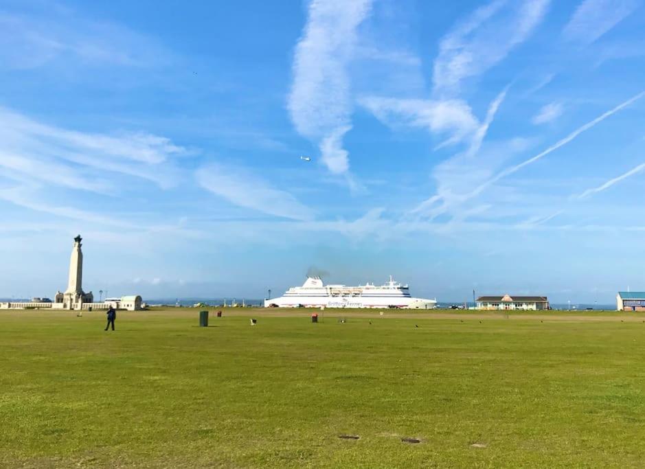 a cruise ship in a field with a person standing in the grass at Queens Gate in Portsmouth