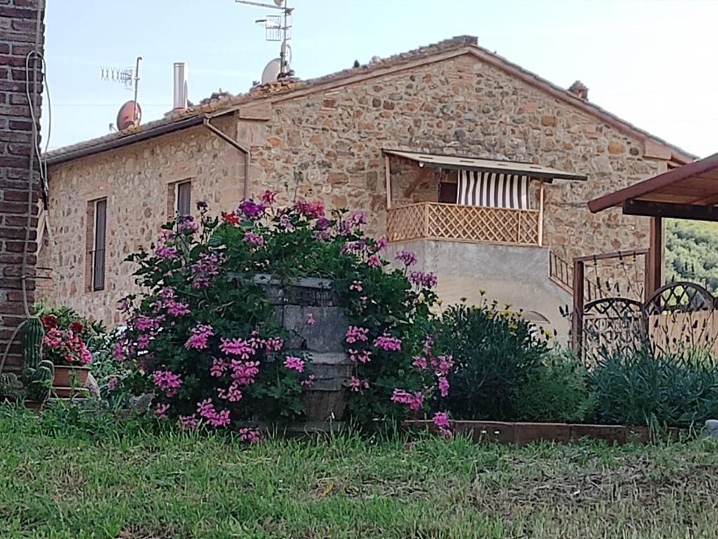 una casa de piedra con flores delante en Agriturismo Il Borgo della Canapa, en San Benedetto