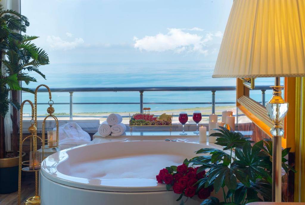 a tub in a room with a view of the ocean at Andalouse Elegant Suite Hotel in Trabzon